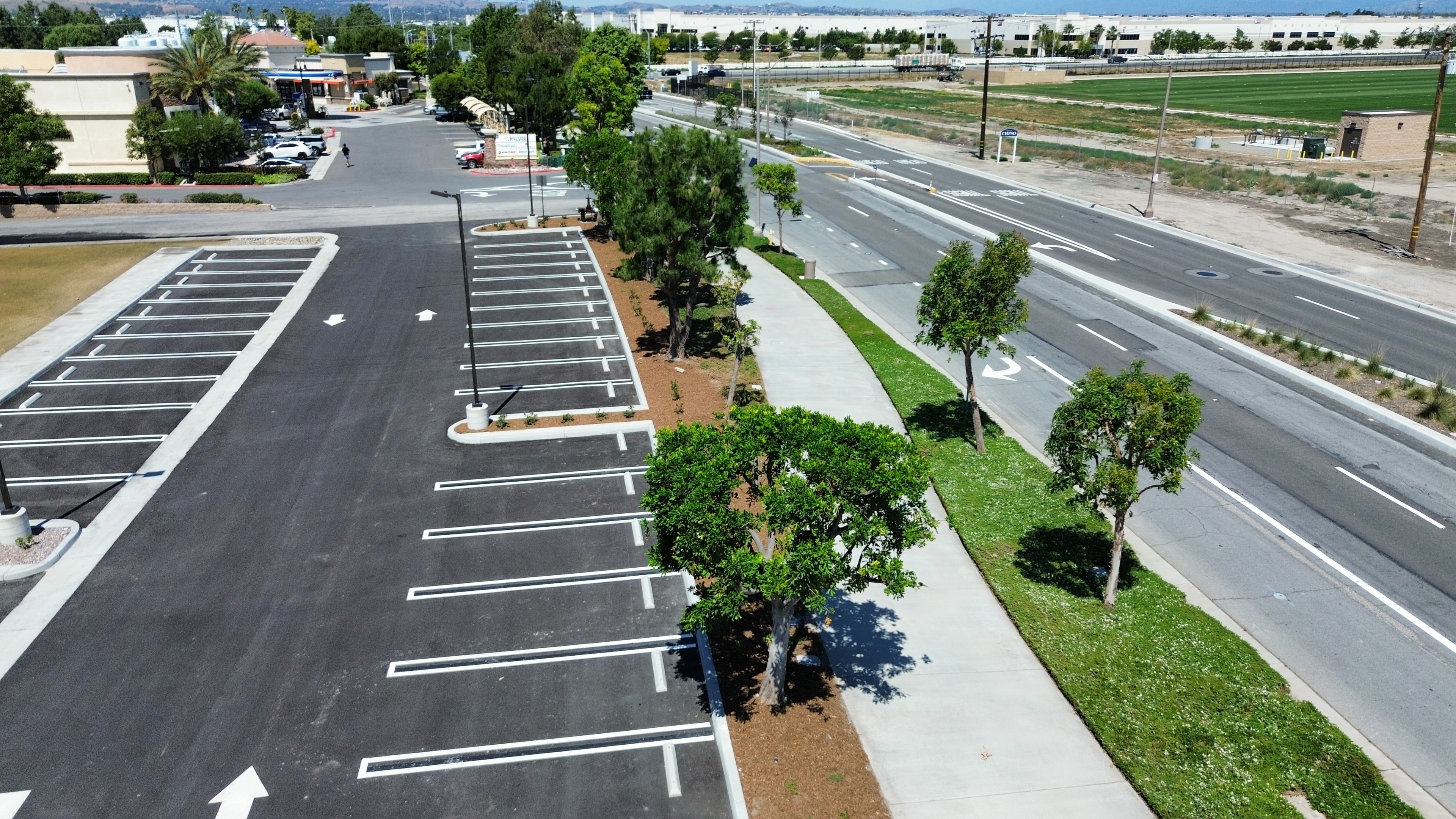 Aerial view of commercial parking lot with tree-lined landscaping maintained by Kirton's Landscape Maintenance, Inc.