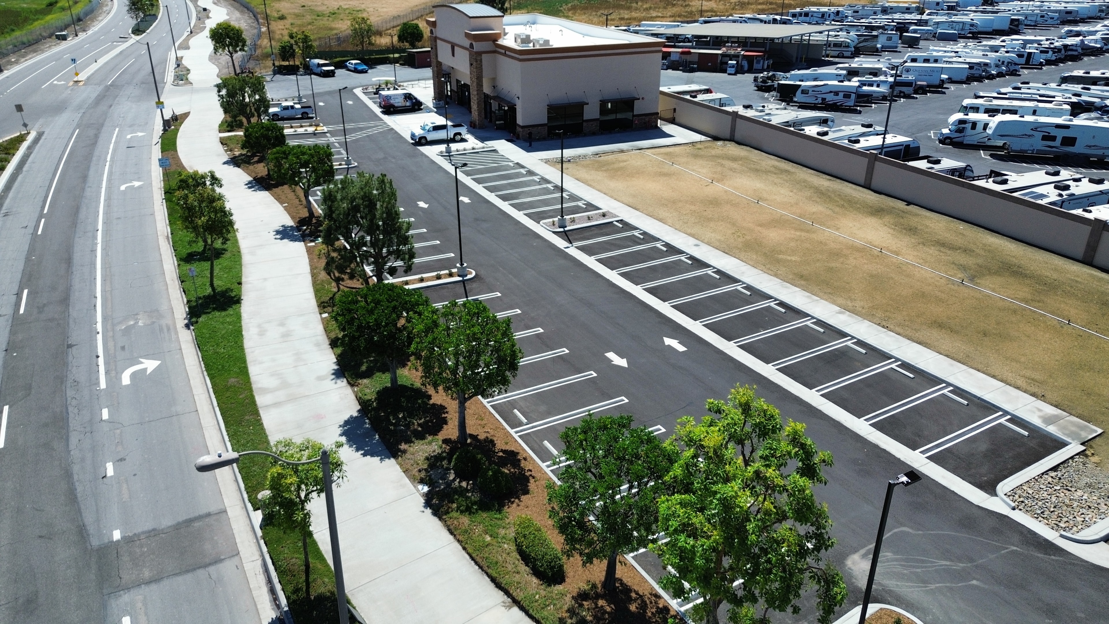 Aerial view of commercial property parking lot with mature tree landscaping maintained by Kirton's Landscape Maintenance, Inc.